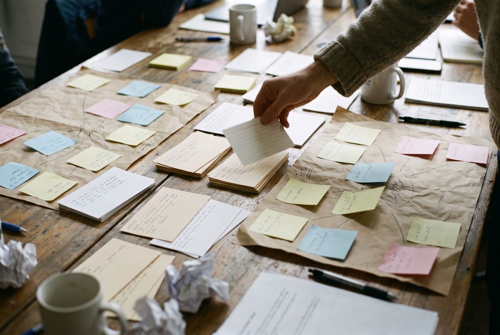 Index cards and sticky notes sorted into groups on a studio table
