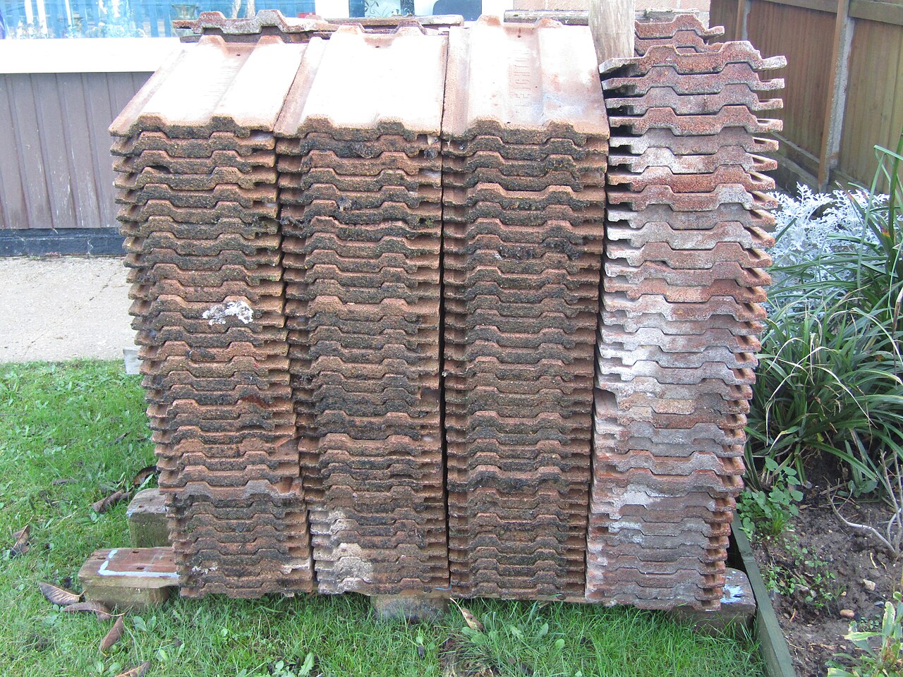 A pallet of reclaimed concrete roof tiles stacked for re-use
