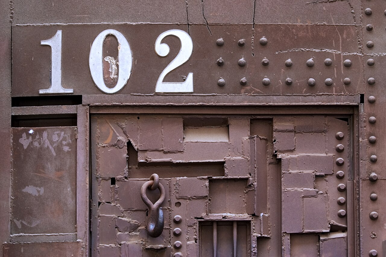 Close view of an artistic steel entrance door in Soho, New York, with riveted panels and sculptural metalwork