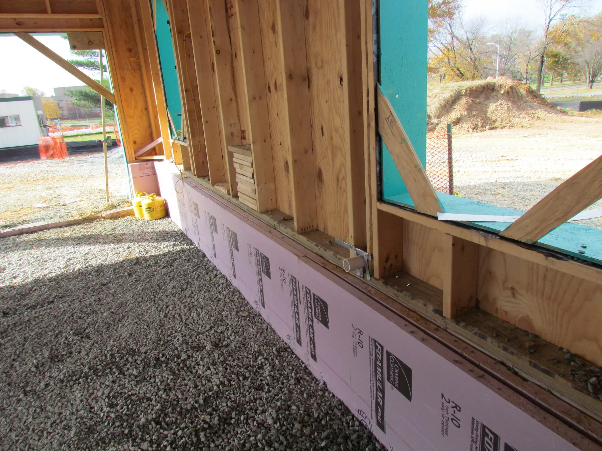 Extruded polystyrene insulation boards placed against concrete knee walls before a garage floor is poured