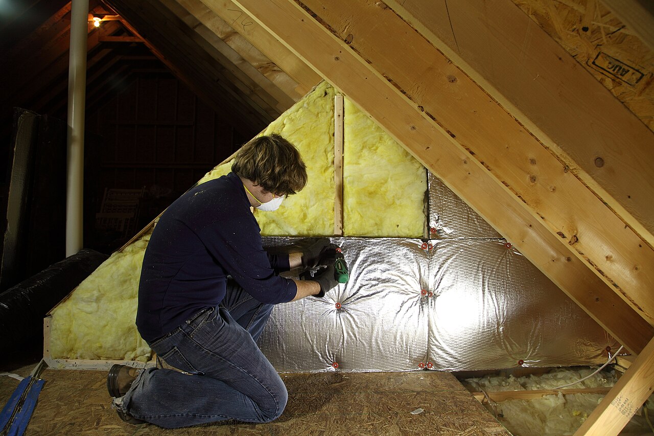 Insulation being installed in an attic roof space
