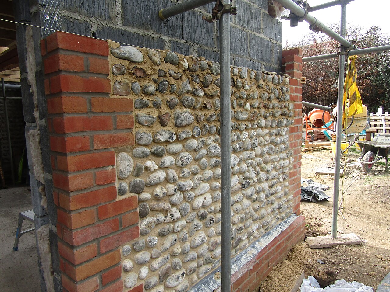 Flint walls being built between brick quoins on a new house in Northrepps, Norfolk
