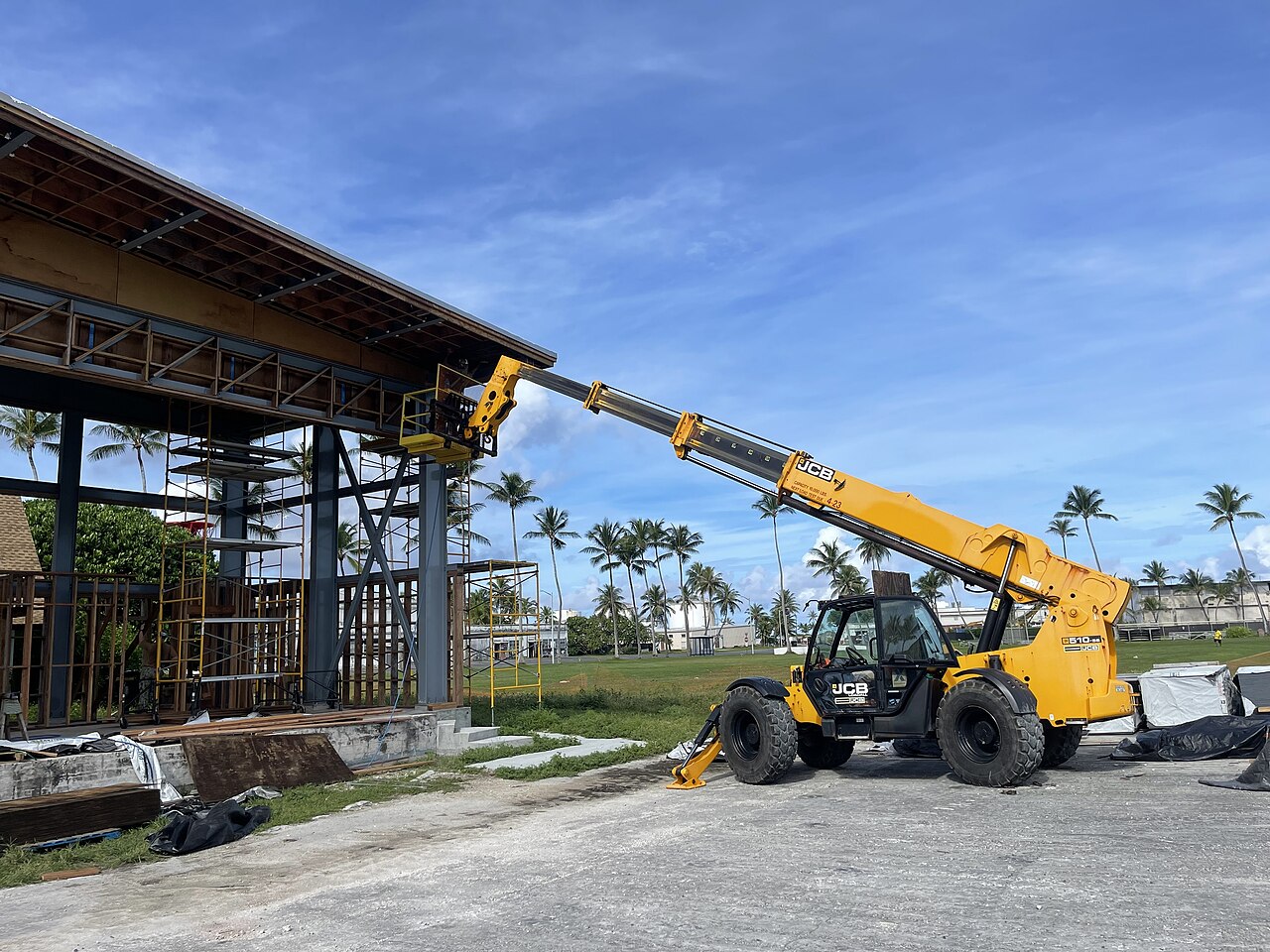 Construction workers installing soffit boards at the eaves of a building