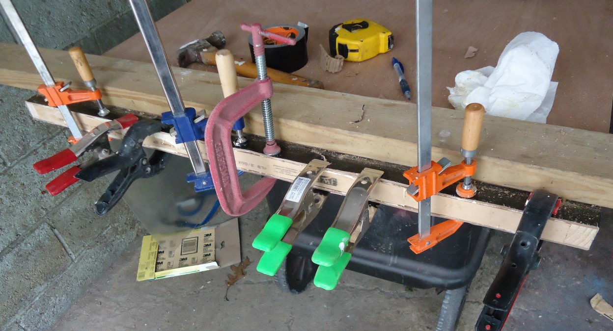 A hollow-core interior door leaf held in clamps while the bottom rail is glued back after the leaf was shortened