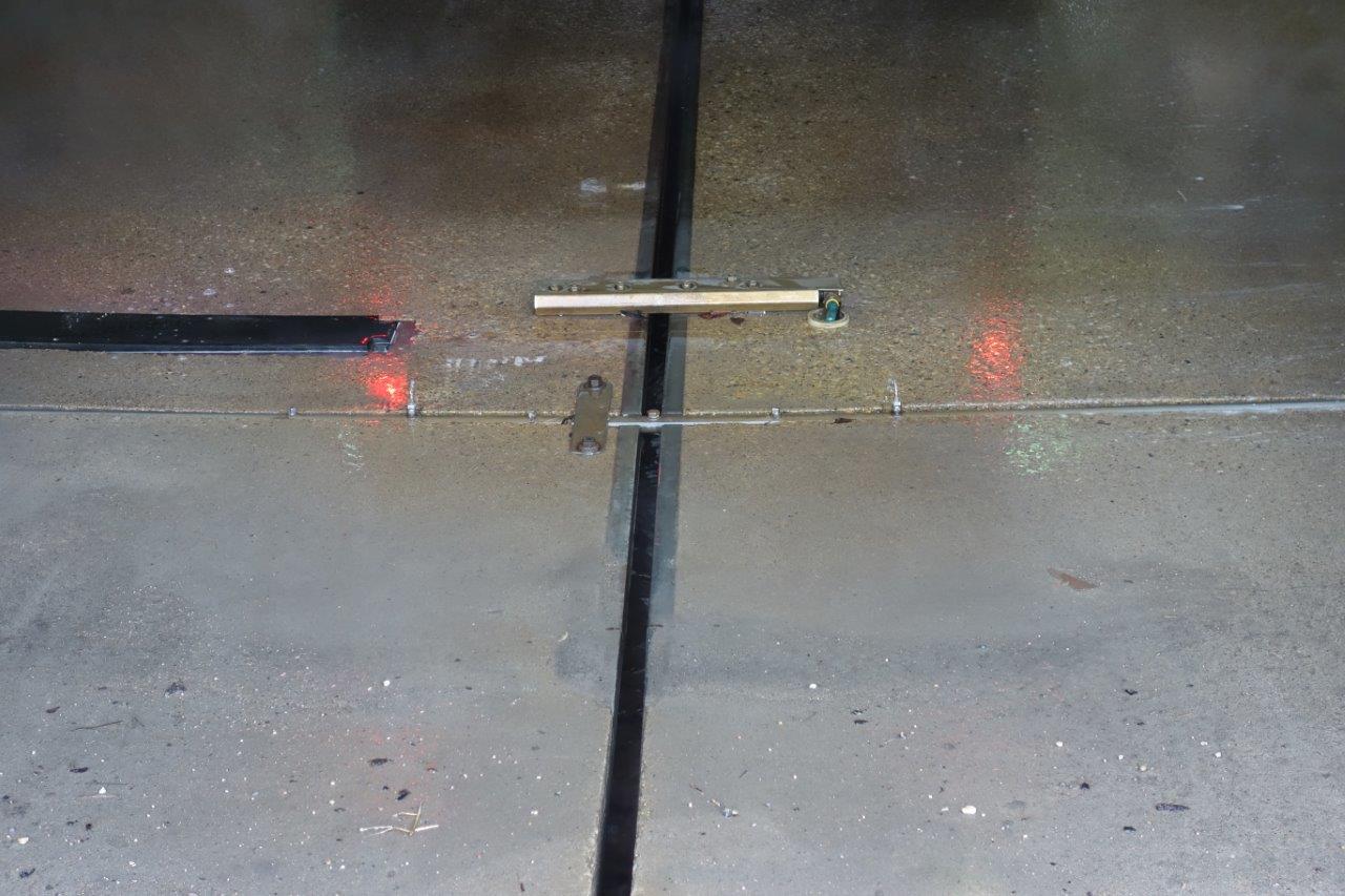 A linear slot drain set into the concrete floor of a car wash