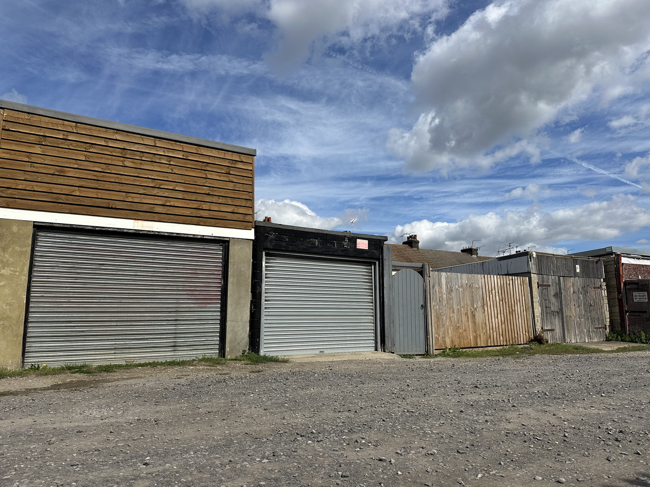 A row of garages in Gillingham with roller shutter and timber doors