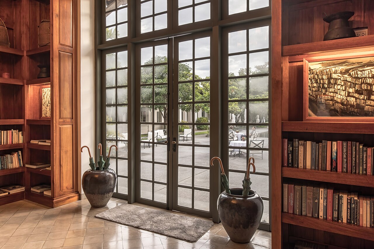 A glass door between a hotel library and a terrace