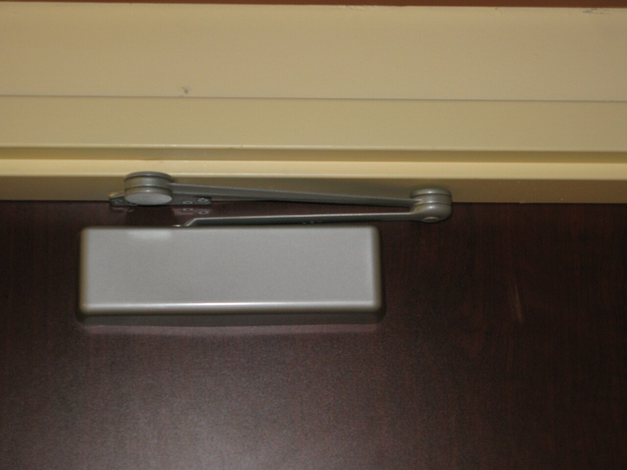 An overhead door closer fitted to a fire exit stairwell door