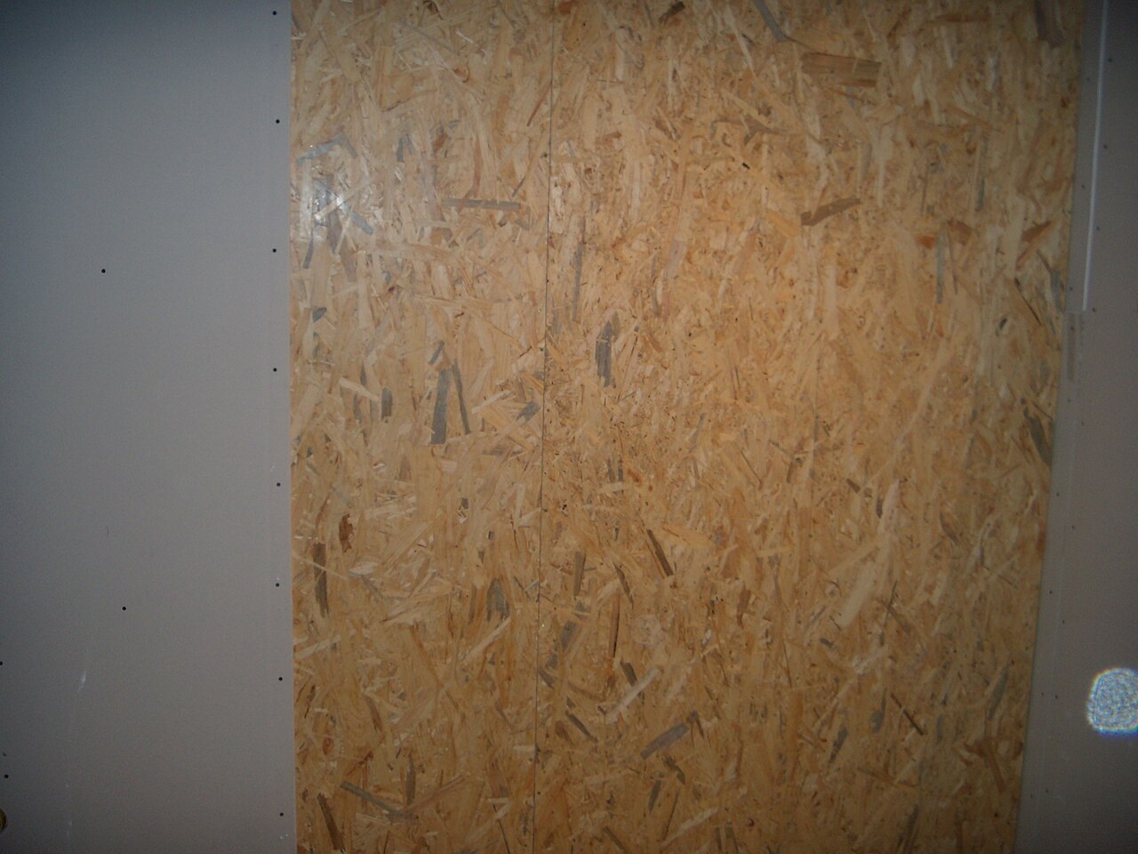 Close-up of an oriented strand board surface showing the wood strands