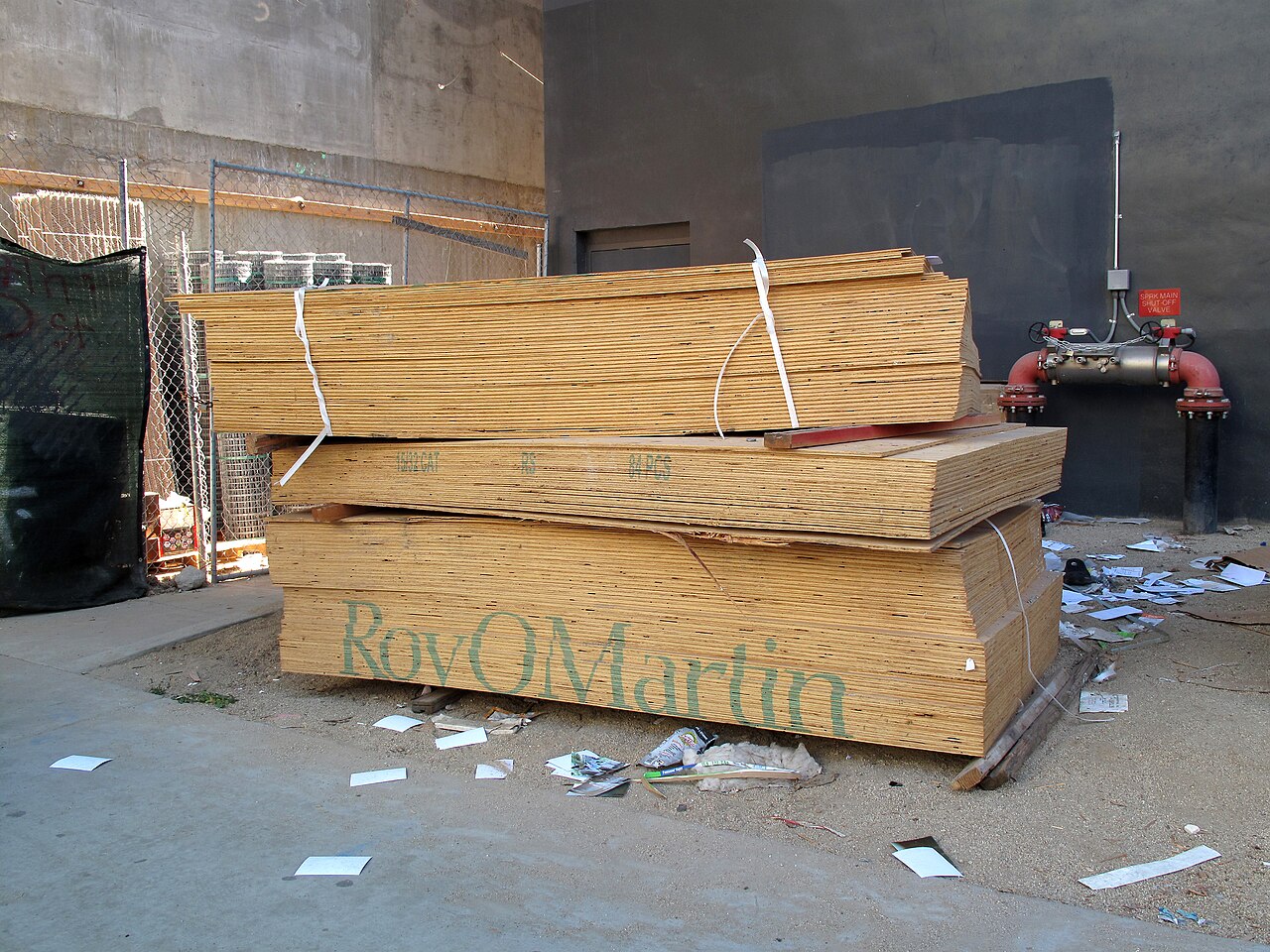 Stacked plywood panels at a manufacturer's yard, ready for construction use
