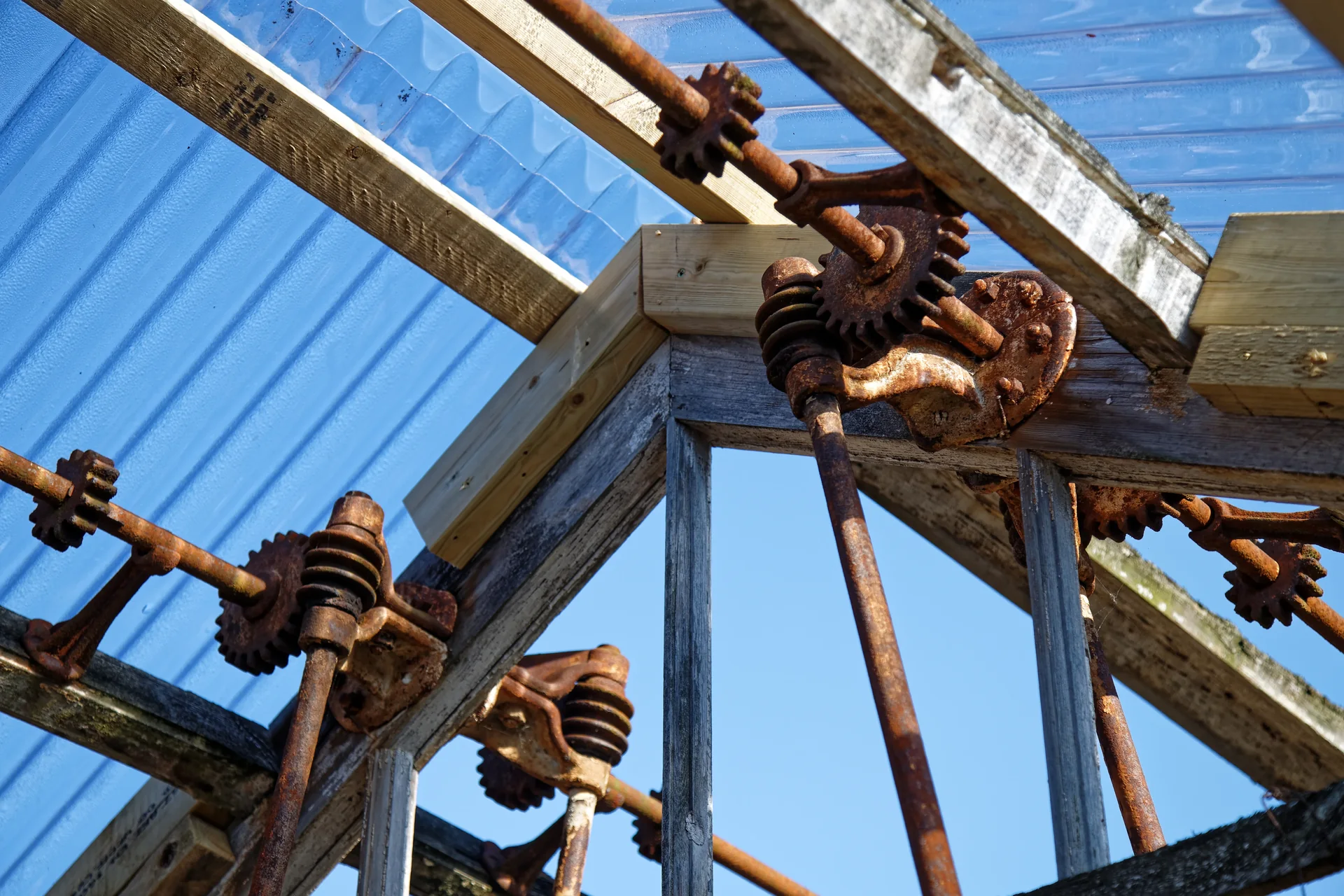 An old greenhouse at Copped Hall, Essex, restored with corrugated polycarbonate roofing, with its rusted vent mechanism