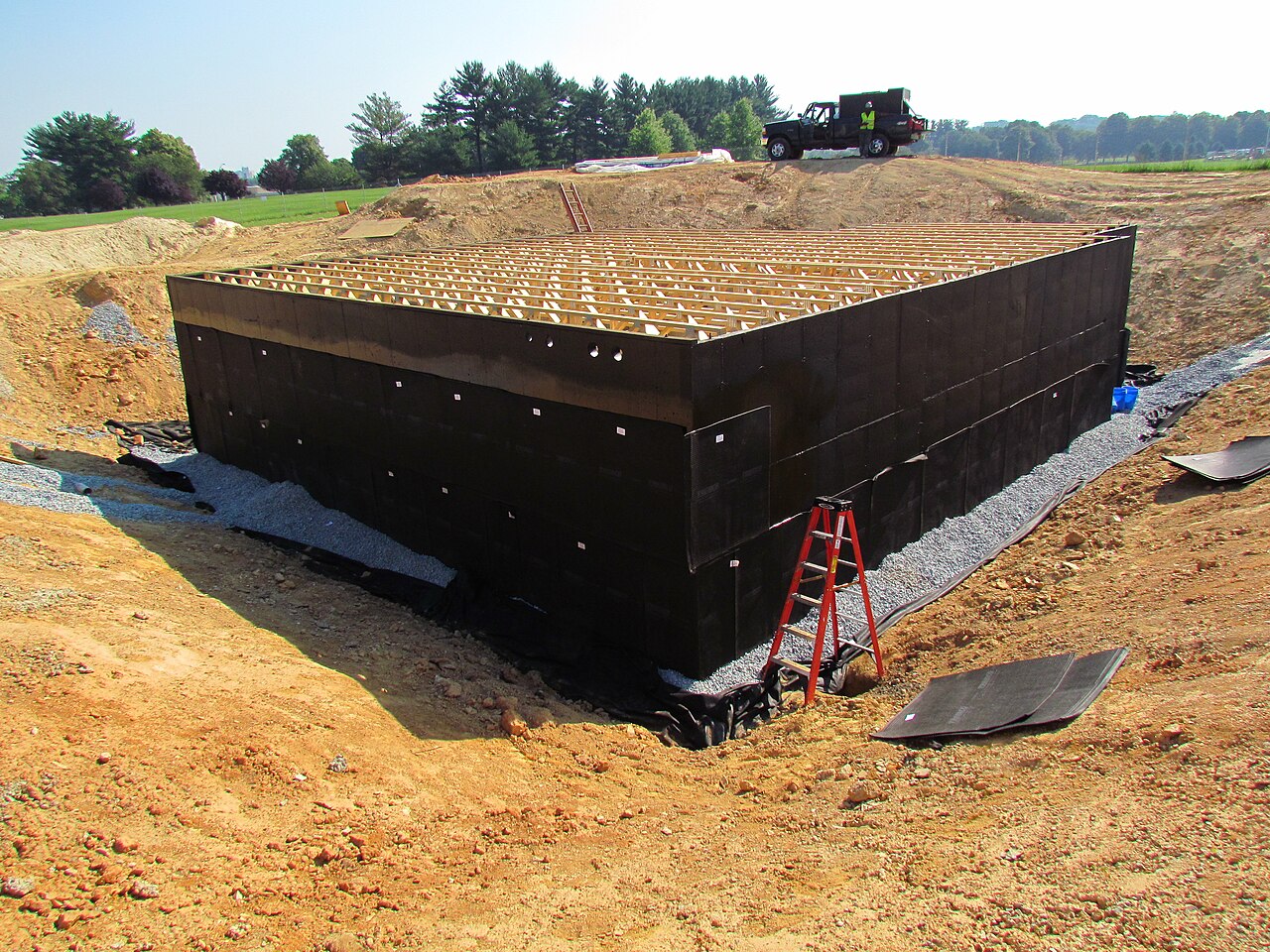 New basement walls with waterproofing applied to the outside face during construction
