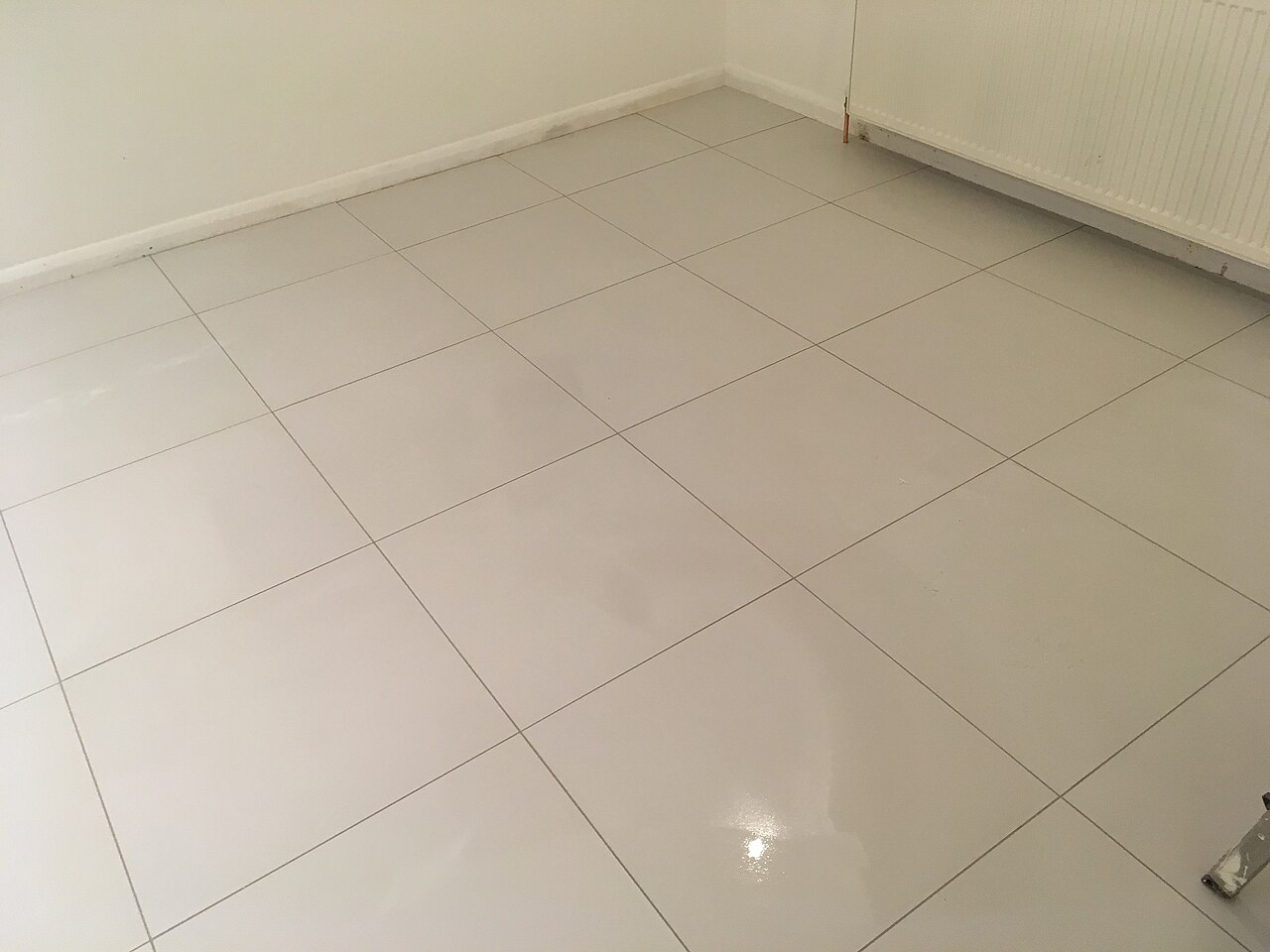 Large-format polished porcelain floor tiles laid with narrow joints