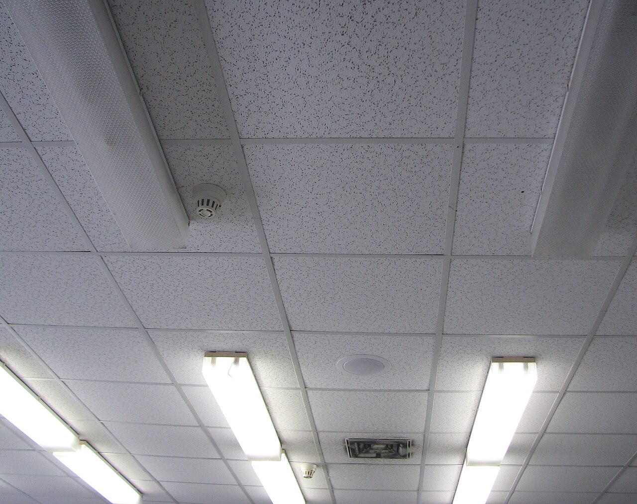A suspended ceiling of lay-in tiles in an exposed grid
