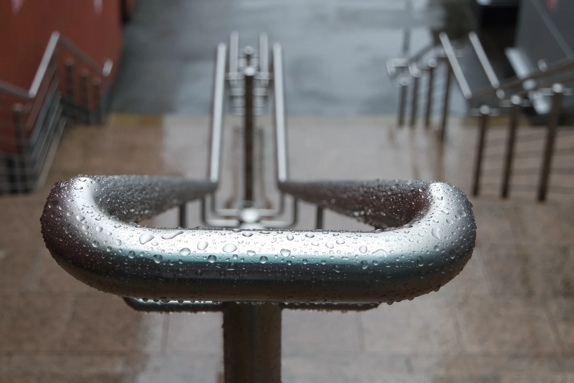 A wet handrail at the Golden Square entrance, seen looking down the steps