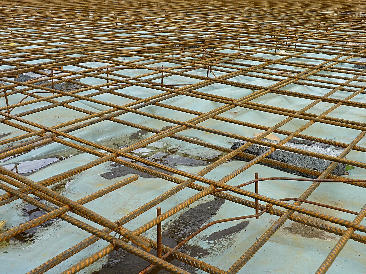Steel reinforcement for a concrete slab placed on a plastic sheet, photographed in Belgium