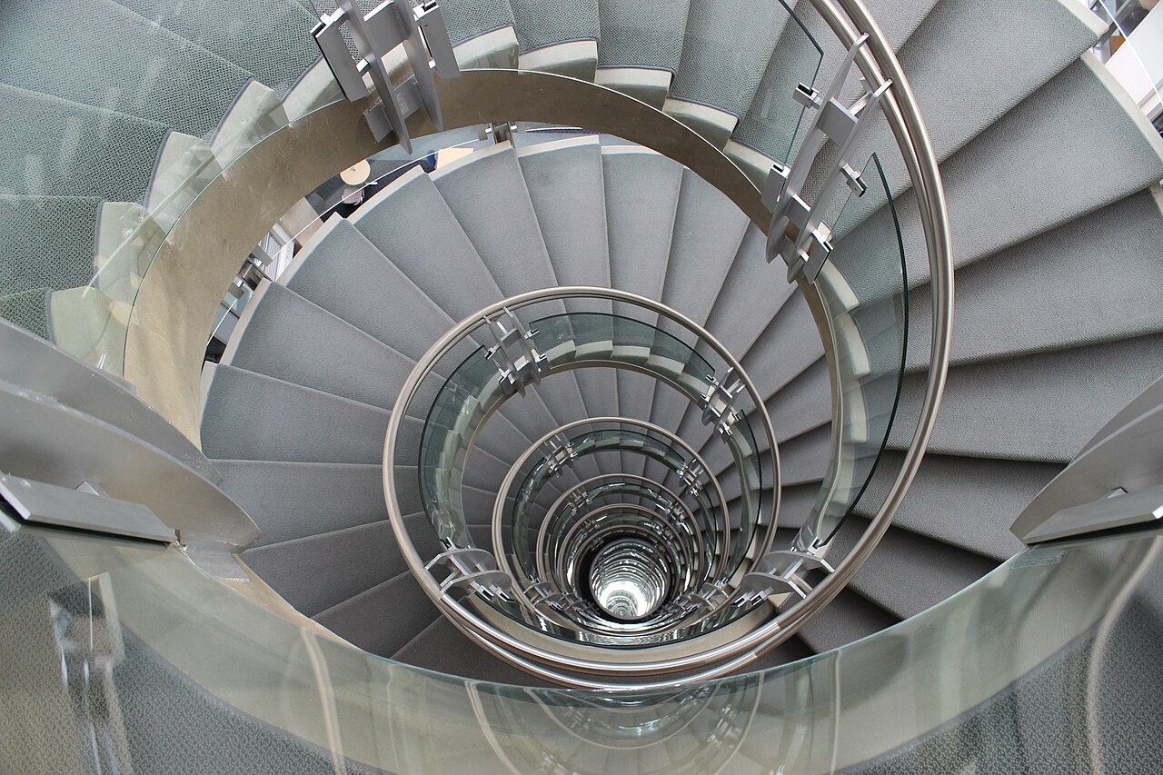 A large sculptural spiral staircase in the atrium of the Keck Center in Washington, D.C.