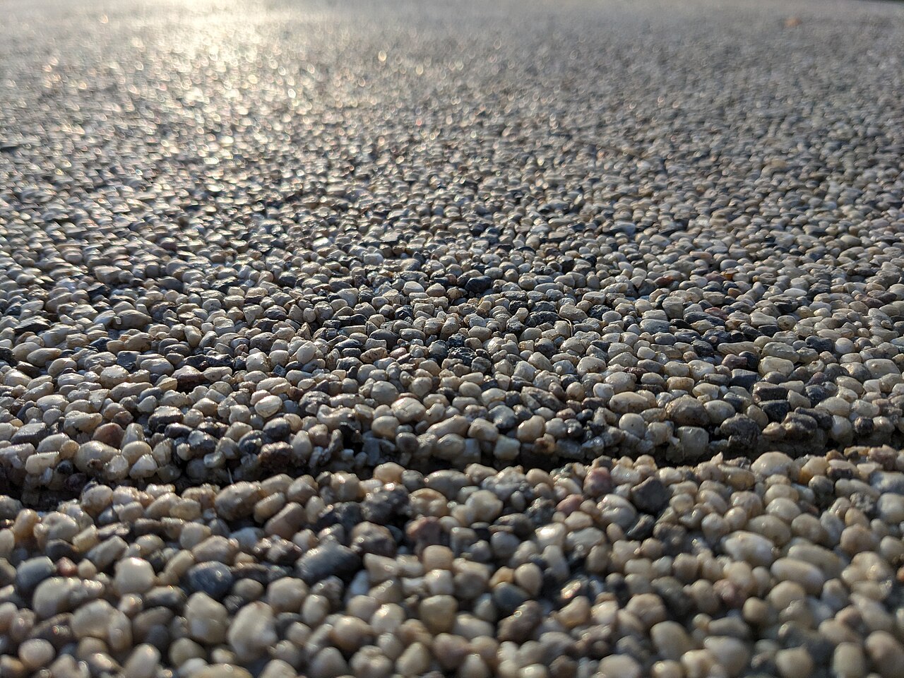 Close view of a resin-bound aggregate surface showing the coated stones