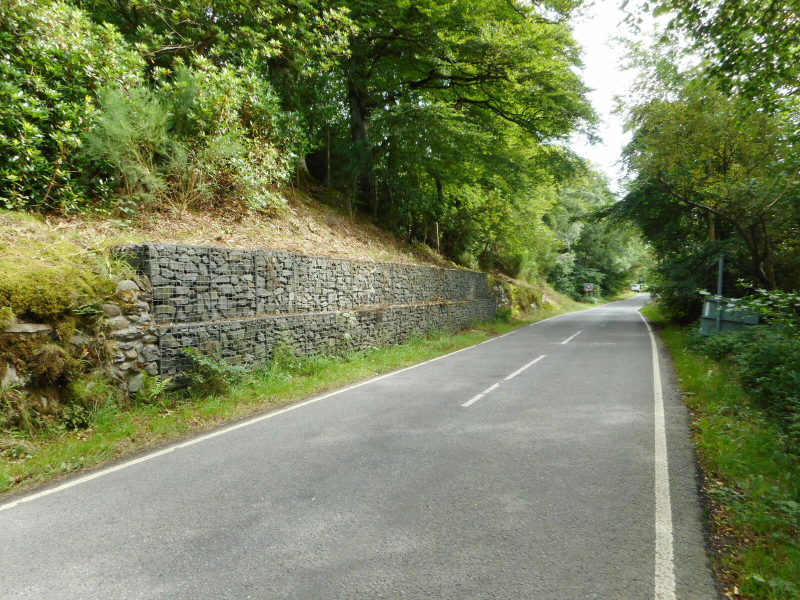 A gabion retaining wall of stone-filled wire baskets