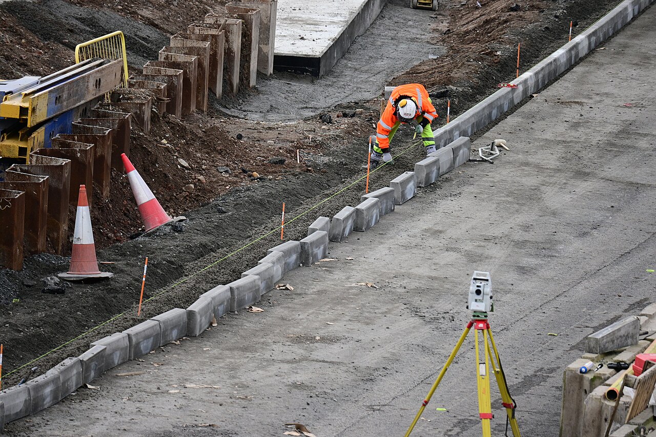 A construction worker laying kerbstones on a new road sliproad in Hull