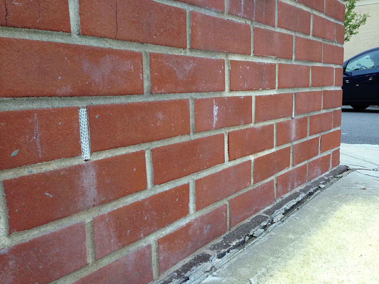 Weep holes with plastic grid inserts in a brick wall