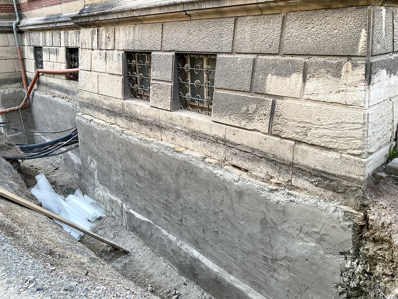 A rendered stone basement wall prepared before a waterproof coating is applied