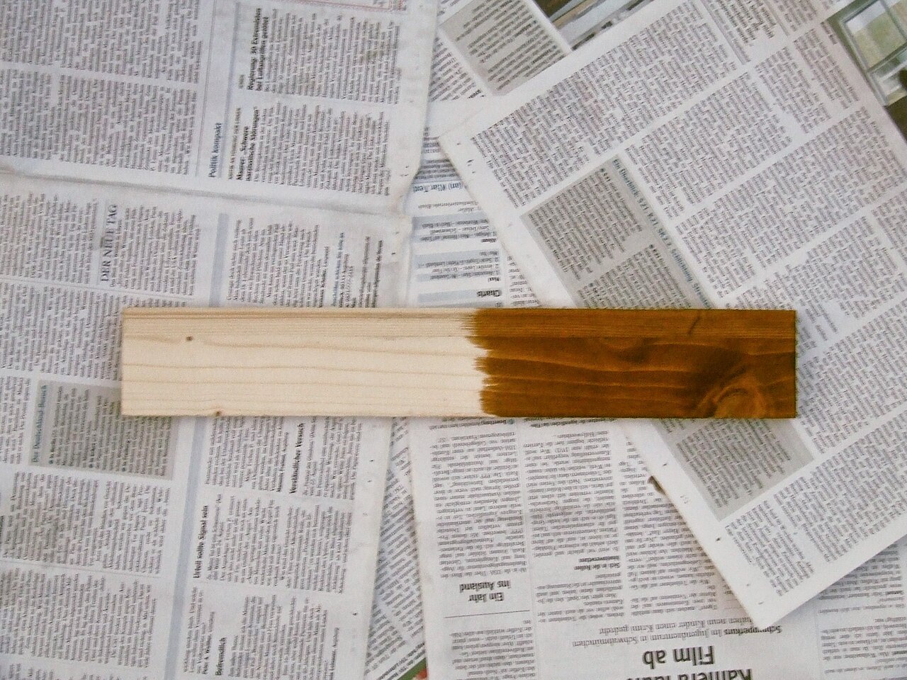 Spruce board with the right half stained and the left half left bare