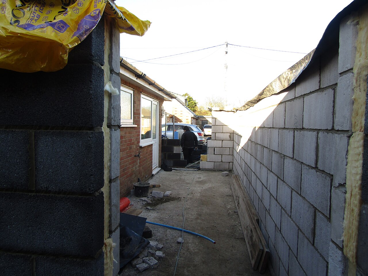 A cavity wall under construction with an aerated concrete block inner leaf and a concrete block outer leaf