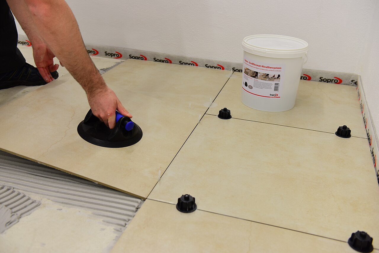 Floor tiles being laid using a tile levelling system