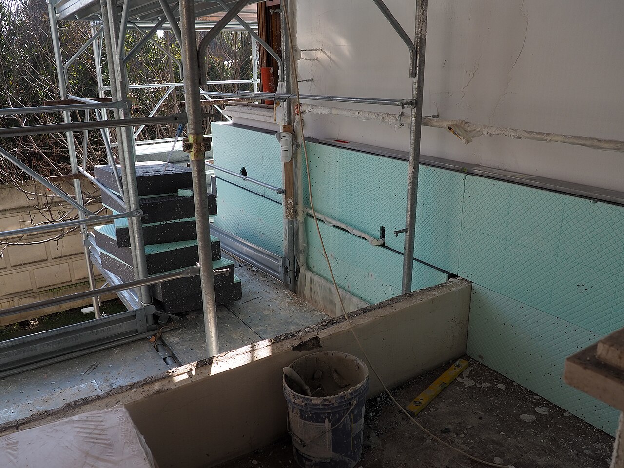 Early stage of external wall insulation being installed on a residential block in Rovigo, Italy