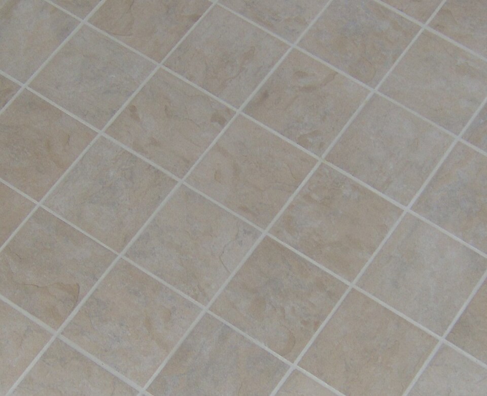 Pale square porcelain floor tiles with narrow grout joints, laid in a diagonal pattern.
