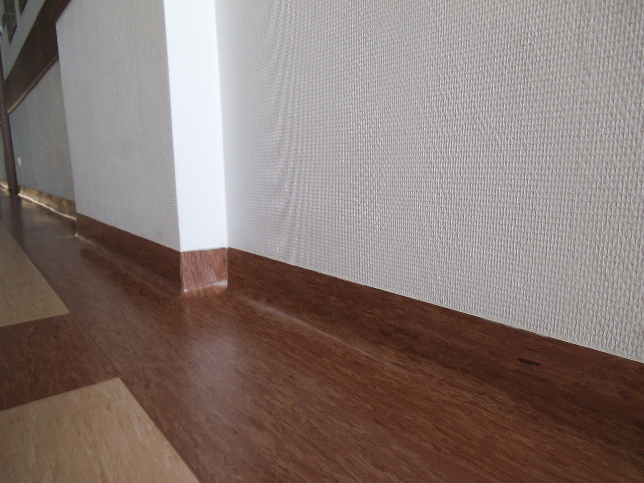 A skirting formed by turning the floor covering up onto the wall
