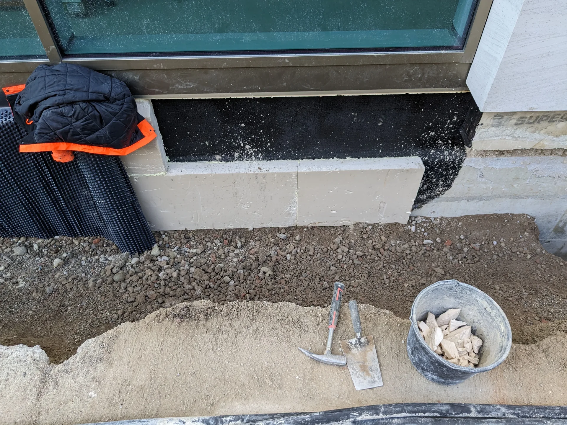 Reinforced concrete basement wall with a bitumen membrane, perimeter insulation and a studded drainage sheet