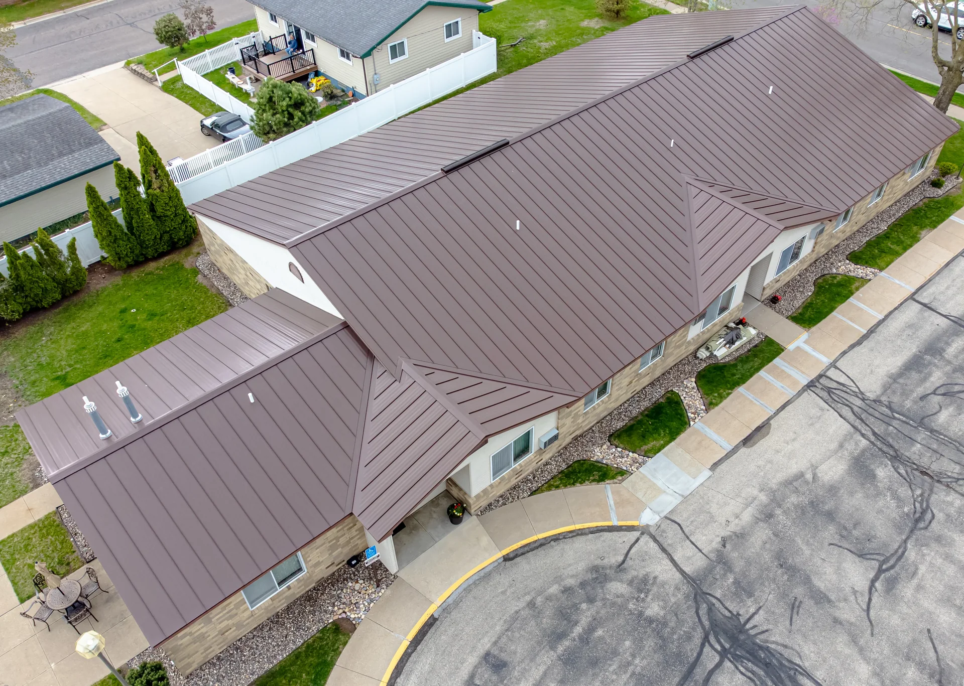 A pitched roof covered in standing seam metal sheets running from eaves to ridge