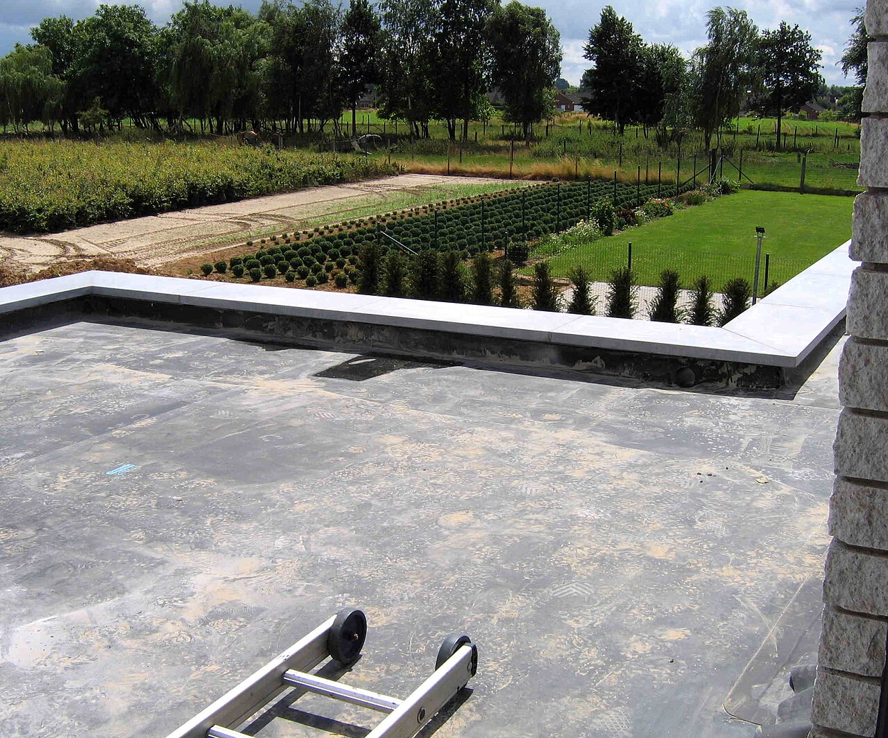 An EPDM membrane laid over a first layer of bitumen on a flat roof under construction