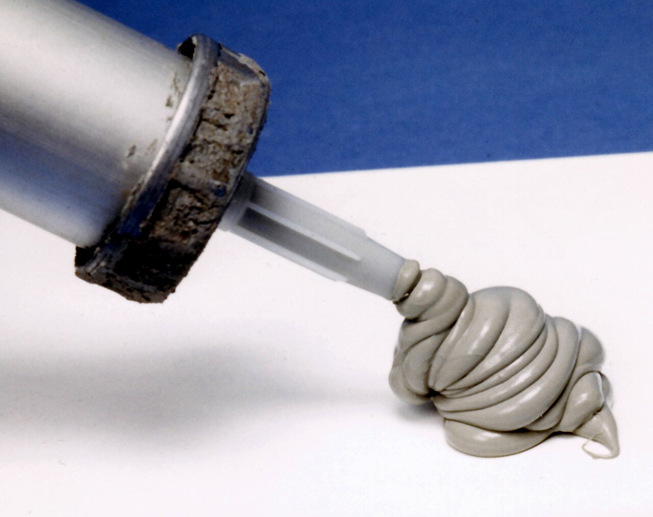Silicone sealant being extruded from a caulking gun