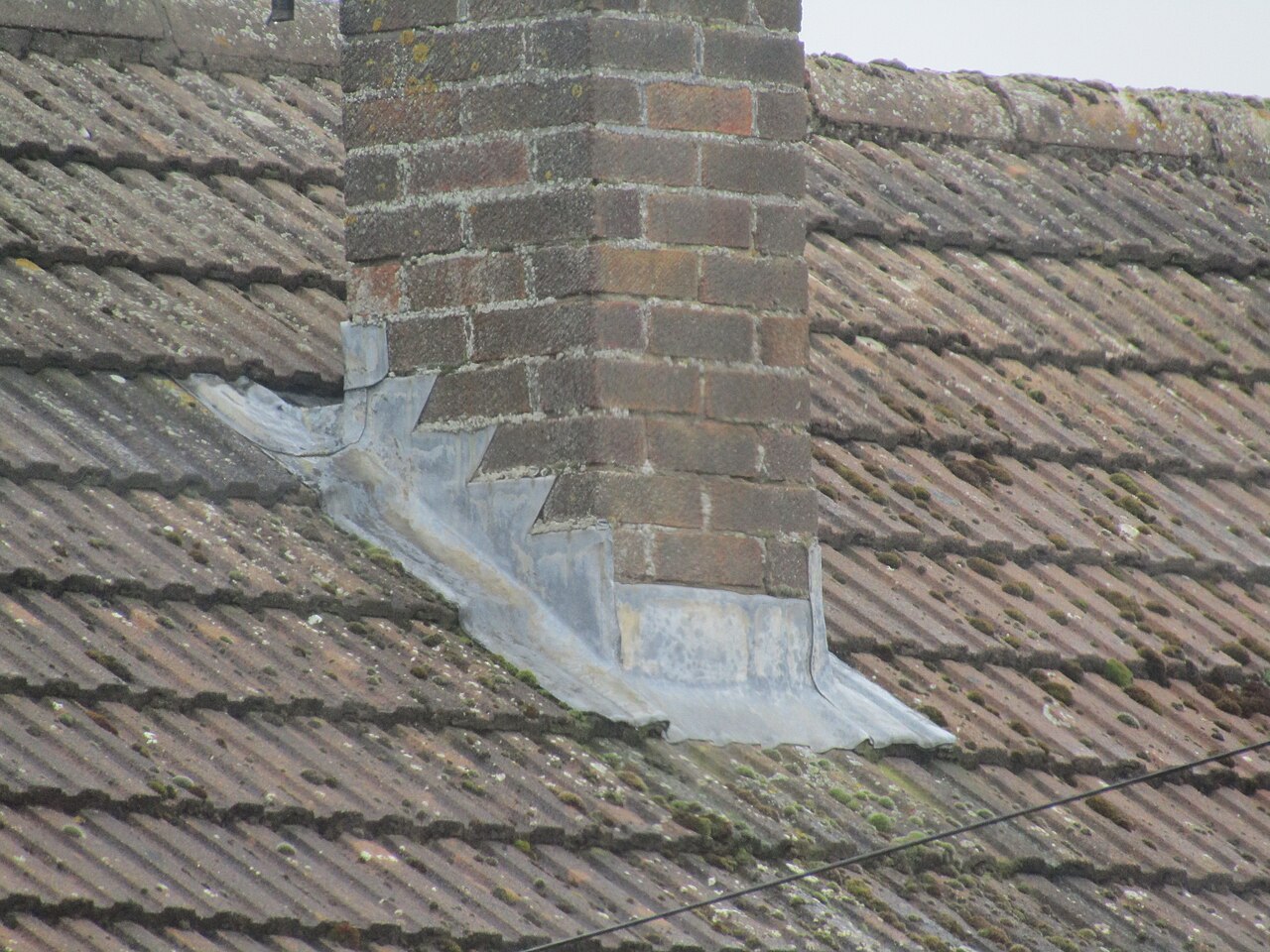 Lead flashing around a chimney stack on a bungalow roof in Trimingham, Norfolk